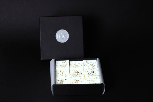 A black box with a silver logo contains botanical wax melt cubes.