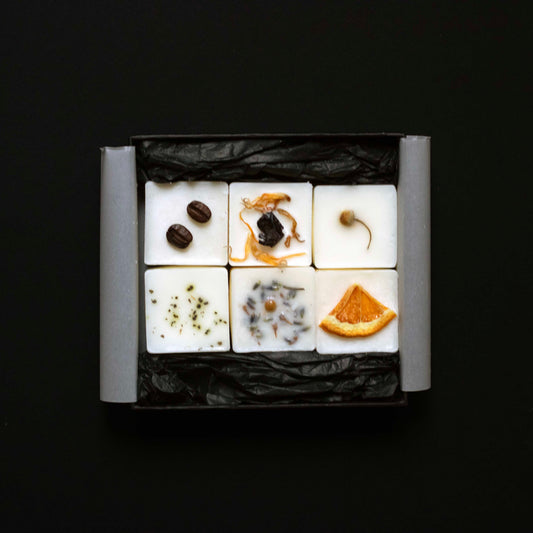 Six wax melts cubes arranged in a square grid on a black background