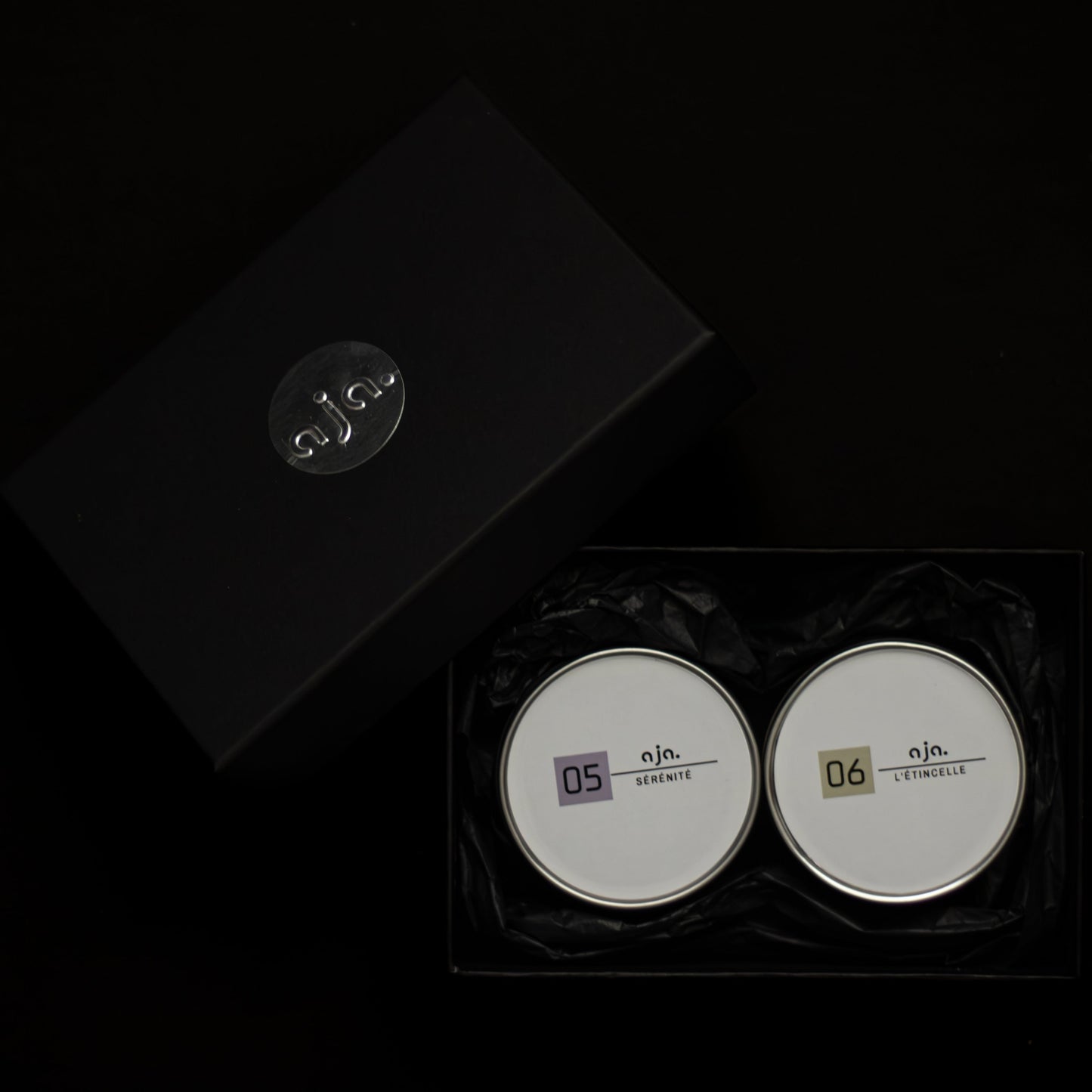Two set of scented candles with labels on a black background. Perfect gift for candle lovers