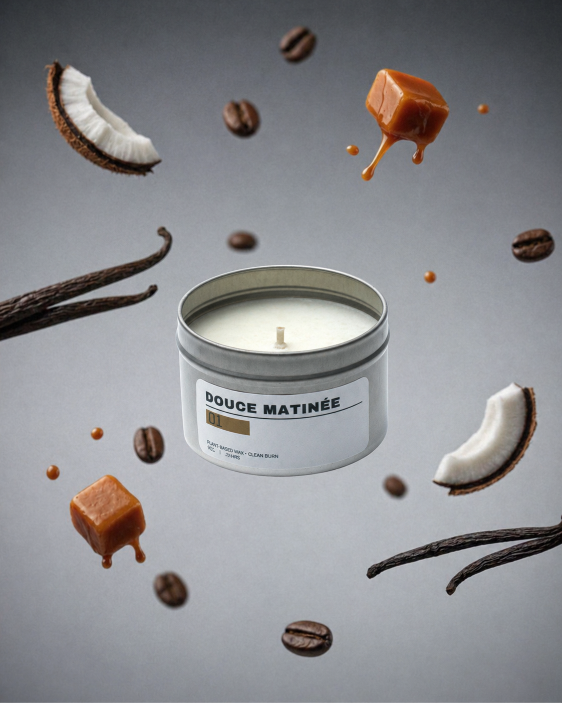 Candle in a tin labeled 'Douce Matinée' surrounded by coffee beans, caramel, coconut, and vanilla on a gray background.
