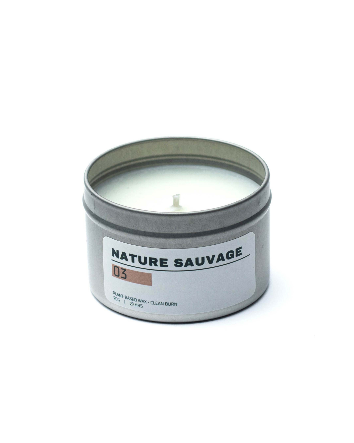 Candle in a metal tin labeled 'Nature Sauvage' on a white background