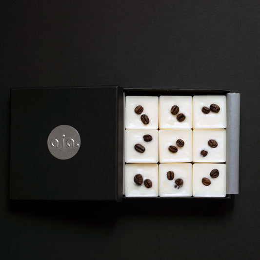 Black box with a grid of wax melts cubes with coffee bean toppings
