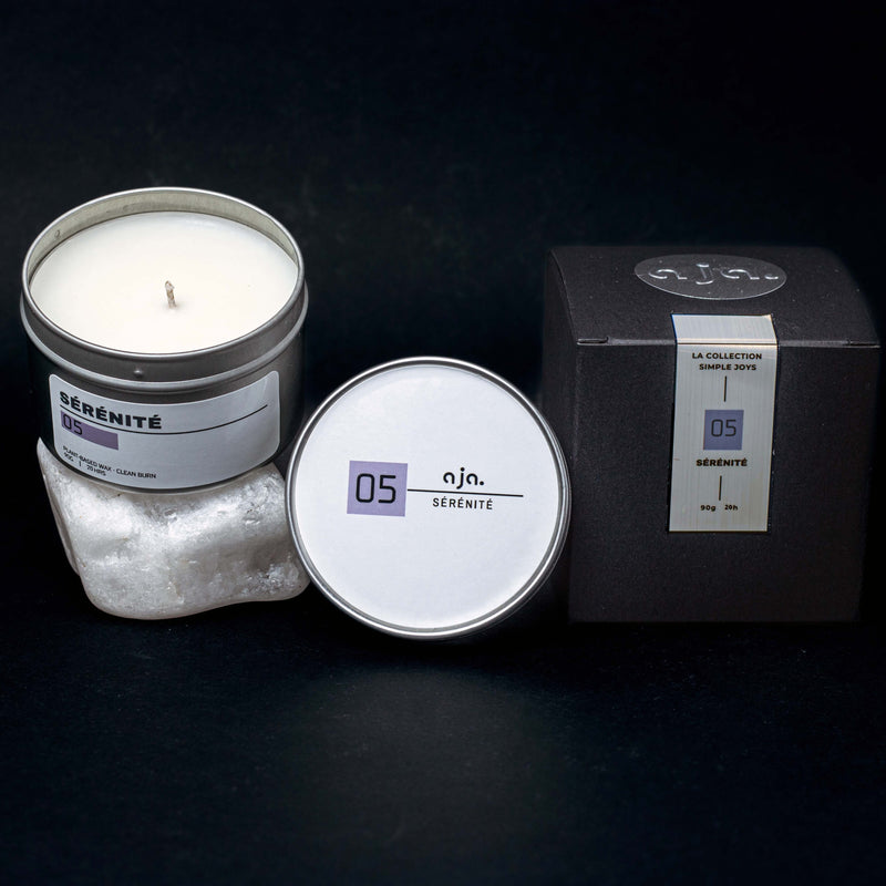 Candle in a tin with packaging on a dark background