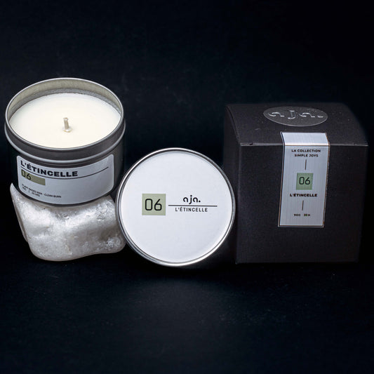 Candle in a tin with packaging on a dark background