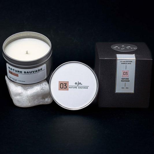 Candle in a tin with packaging on a dark background