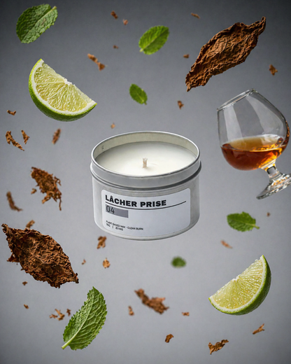 Candle in a tin with 'Lácher Prise' branding, surrounded by lime slices, tobacco leaves, and a glass of alcohol on a gray background.