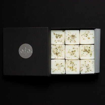 a black box packaging, inside it are wax melt cubes with botanical on top