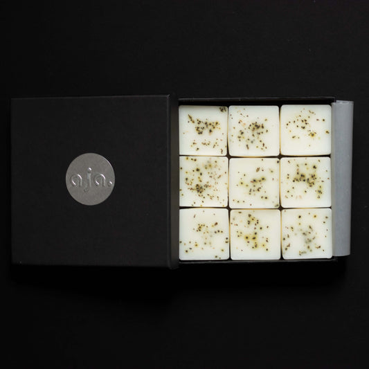 a black box packaging, inside it are wax melt cubes with botanical on top