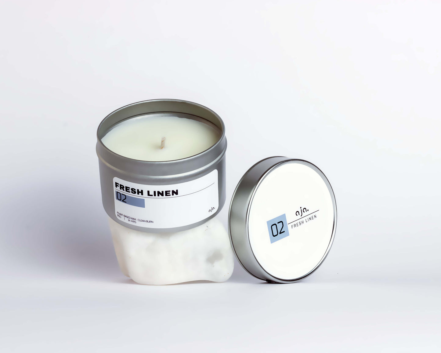 Candle in a tin with 'Fresh Linen' label on a white background