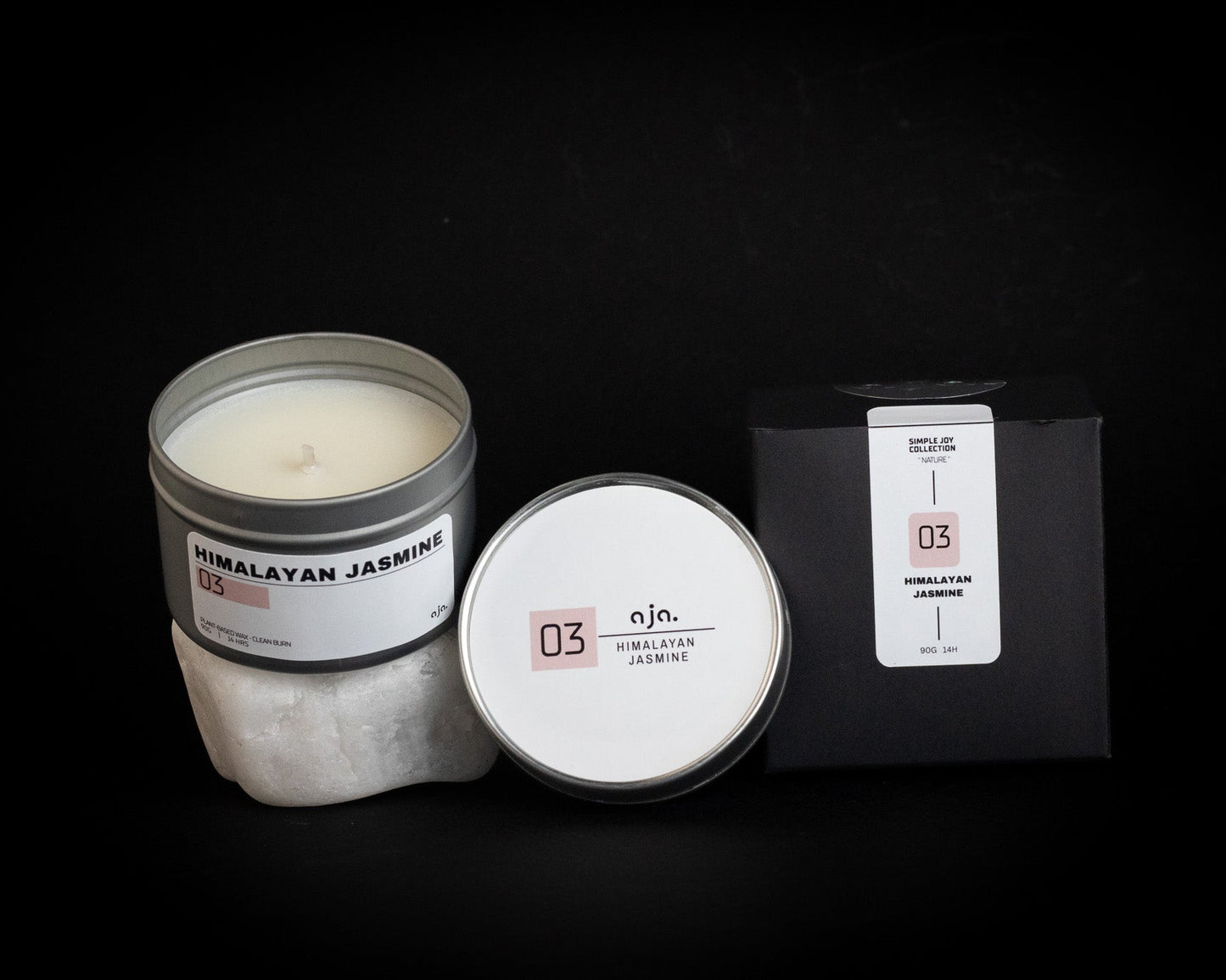 Candle with packaging and label on a black background