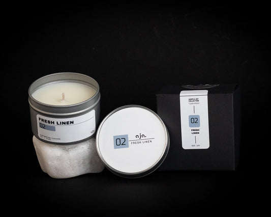 Candle with packaging labeled 'Fresh Linen' on a black background, Premium Scented Candle made with natural rapeseed and coconut wax