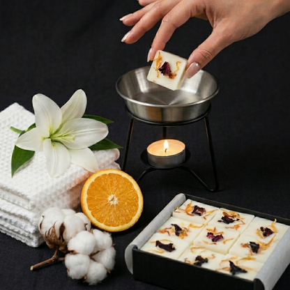 botanical wax melt with cotton, orange and lily as representation of fragrance.